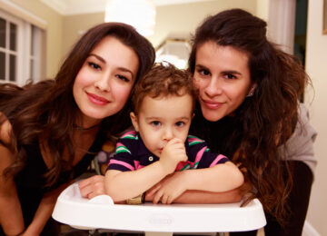 Close up portrait of a cute baby boy with family in a home setting.